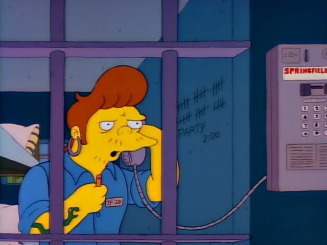 Homer talks on a phone in a dim room with a green door and a potted plant, while a prisoner with reddish hair and a blue…