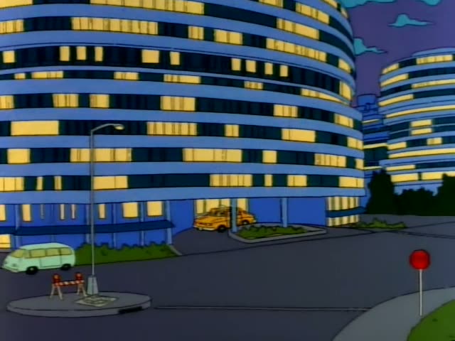Homer, Marge, Lisa and baby Maggie step out of an elevator in a lobby where a bellhop in a red uniform with light blue hair…