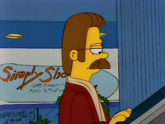 Ned Flanders rides an escalator in a mall, first looking ahead and then turning to gesture with both hands while speaking