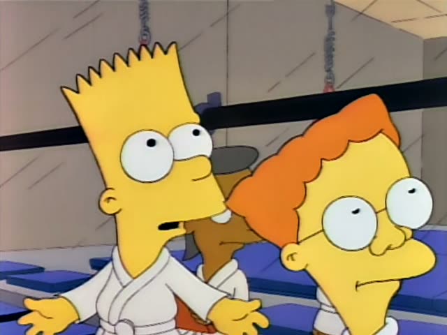 Bart Simpson spreads his arms and talks at a dojo beside an orange-haired boy with glasses, while a thin, black-haired…
