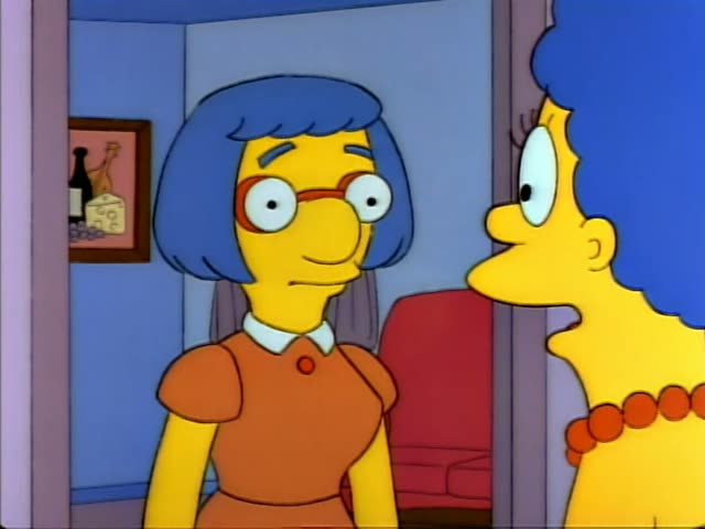 Marge Simpson and a woman with a blue bob, red-framed glasses, and an orange dress with a white collar, are first seen…