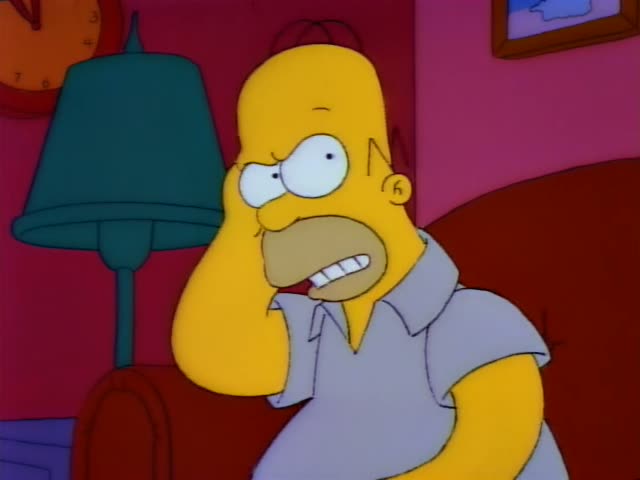 Homer stands in a pink living room beside a green lamp and a red armchair, clutching his head and grimacing with clenched…