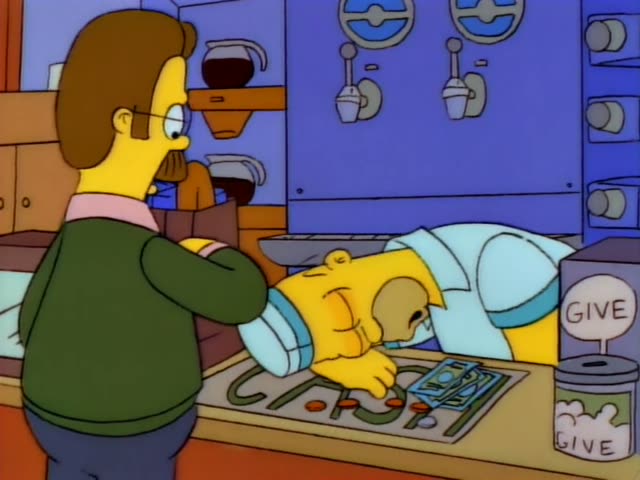 Ned Flanders stands holding a paper bag at the Kwik-E-Mart counter while Homer lies slumped asleep over the counter…