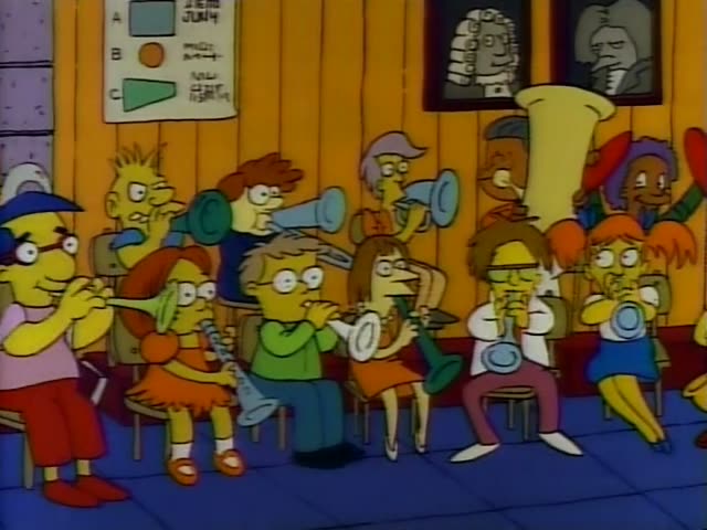 Lisa plays in a school band while a heavy older man in an orange sweater conducts from a music stand, and other kids blow…
