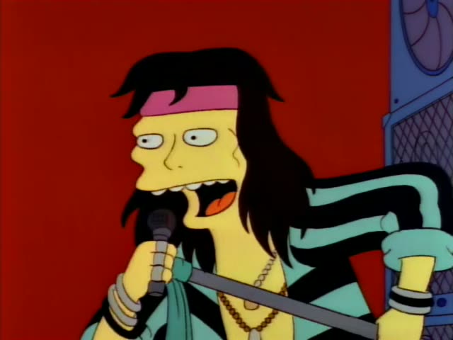 Marge is in a cheering crowd with hands raised, and a bald man in a white jacket and a curly-haired man in a grey-blue…