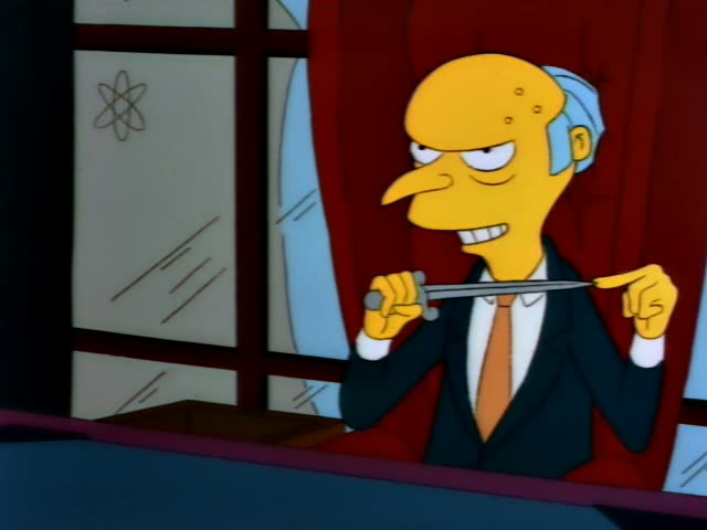 Mr. Burns wears a dark suit and orange tie as he stands by a window with red curtains