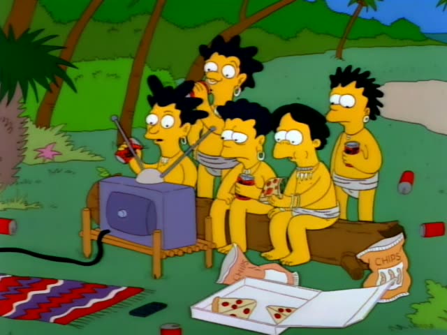 Five yellow, afro-haired islanders in grass skirts sit on a log in a jungle clearing, watching a small grey television…
