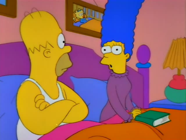 Homer sits propped up in bed with his arms crossed beside Marge, a woman in a purple robe with a tall blue beehive