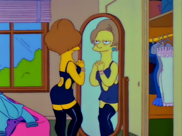 Mrs. Krabappel stands before a tall oval floor mirror in a bedroom with a window and an open closet, trying on outfits one…