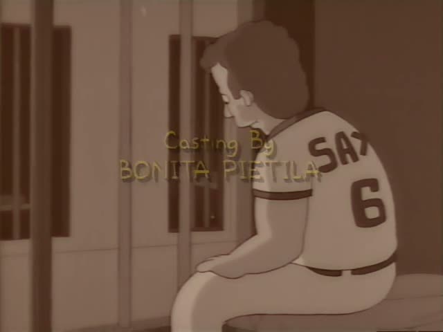 A curly-haired boy in a white baseball jersey marked SAX 6 sits hunched on a bench beside a fence, then Homer Simpson raises…