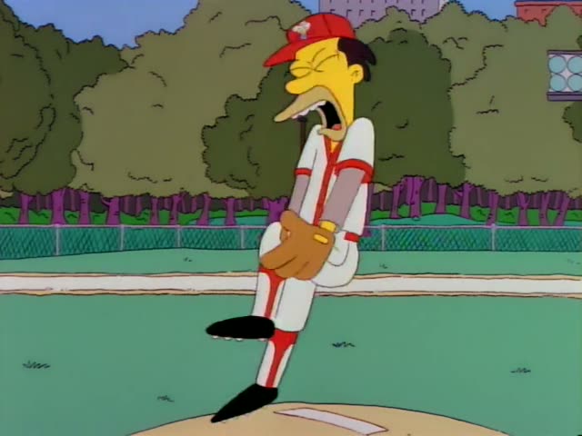 Mr. Burns stands on a baseball pitcher's mound in a white uniform with red trim and a red cap, wearing a brown glove