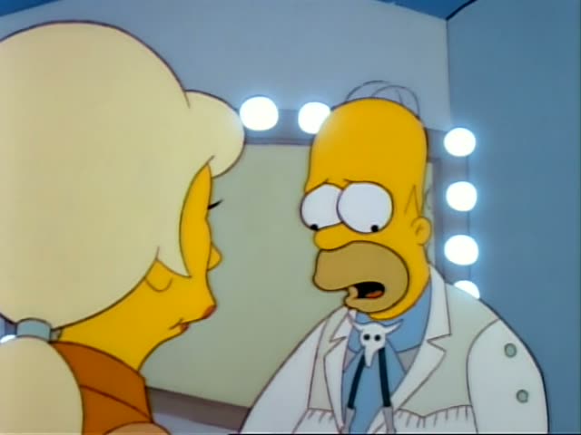 Homer Simpson stands face to face with a blonde woman with a tall, voluminous hairdo and an orange top, in front of a mirror…