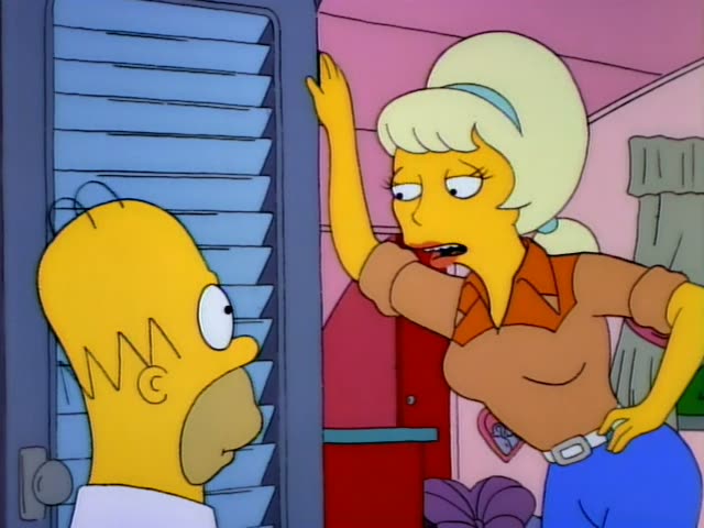 Homer faces a blonde woman with a bouffant hairdo, light blue headband, brown blouse with an orange collar, blue jeans…