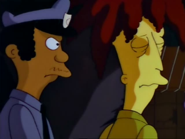 Sideshow Bob is held by two police officers at night while Selma in a pink robe and the Simpson family watch from a porch…