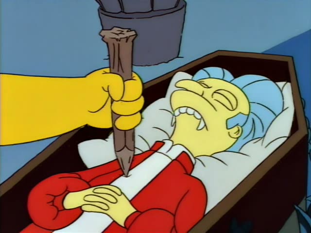 Marge lies in an open coffin in a red cape over a white lining while a yellow hand from the left drives a wooden stake…
