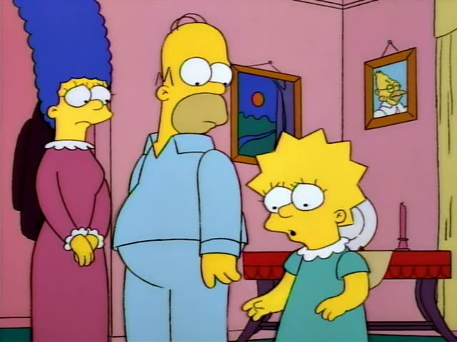 Marge, Homer, and Lisa stand in the pink living room in pajamas and a dressing gown, with Lisa gesturing as Homer looks on