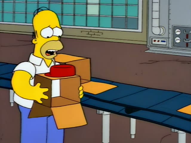 Homer Simpson stands in a factory beside a conveyor belt, clutching stacked cardboard boxes with a red hat on top…