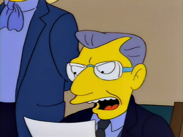 Principal Skinner sits at a desk reading a sheet of paper, then frowns and rests his chin on his hand while a tall blonde…