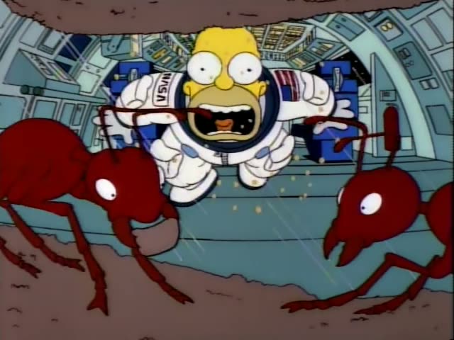 Homer Simpson is swarmed by large red ants inside a metallic space-station-like chamber