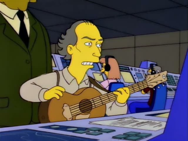 Mr. Burns sits in a dark blue collar inside a cramped grey-blue control room with round portholes