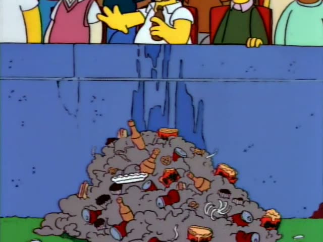 Homer in his white shirt and Ned Flanders in his green sweater, with moustache and glasses, sit among a crowd in red stadium…