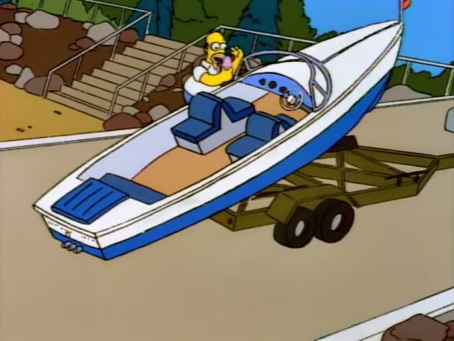 Homer sits at the wheel of a white-and-blue speedboat on a trailer as it is launched down a concrete ramp toward the water…