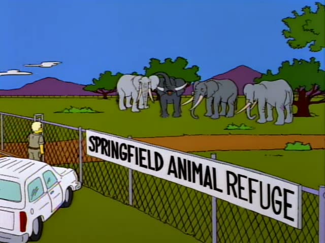 Homer, Marge, Lisa and Bart stand at a fence at the Springfield Animal Refuge, where a keeper in a tan uniform and boots…