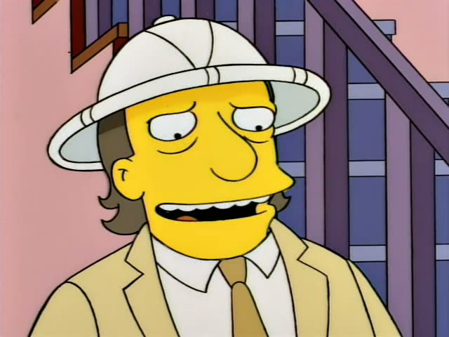 A man in a white pith helmet, tan suit and tie, with a moustache and swept-back brown hair, grins and then smirks in front…