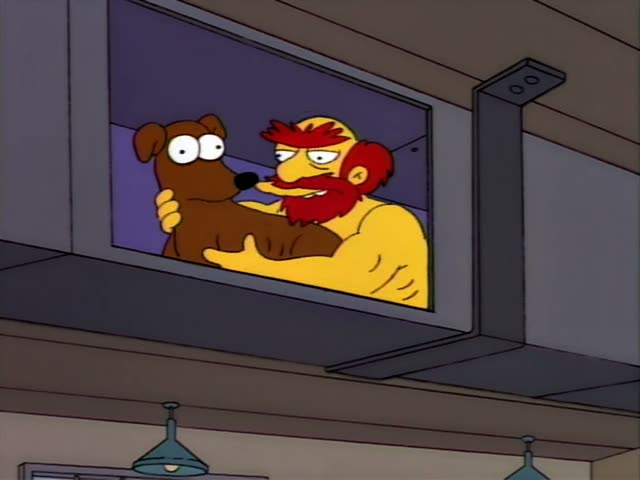 A muscular, shirtless man with a red beard and red hair hugs Santa's Little Helper and the two stare wide-eyed