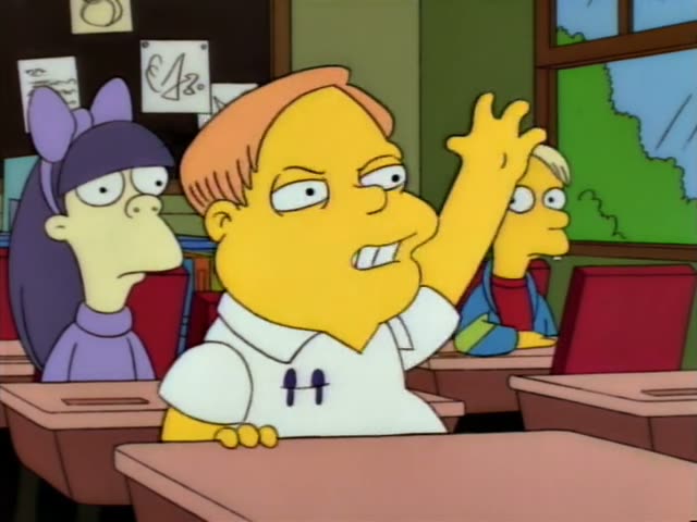 In a classroom with a green chalkboard, an orange-haired boy in a white shirt sits at a desk with his hand raised high…