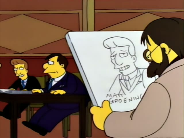 Mr. Burns stands in a blue suit and red tie in a courtroom while a bearded man with long dark hair and glasses in a tan coat…
