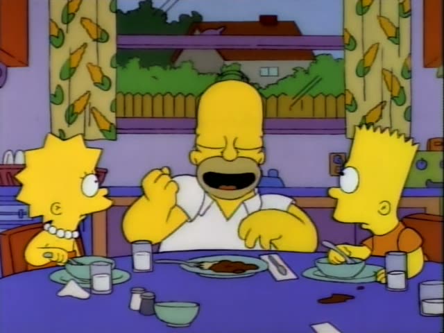 Homer sits at the kitchen table between Lisa and Bart, the boy with spiky hair in an orange shirt