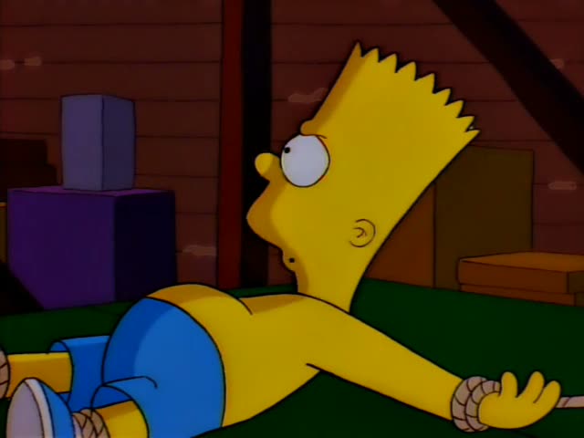 Bart lies shirtless in blue shorts, his wrists and ankles tied with rope to a green table in a wooden attic…