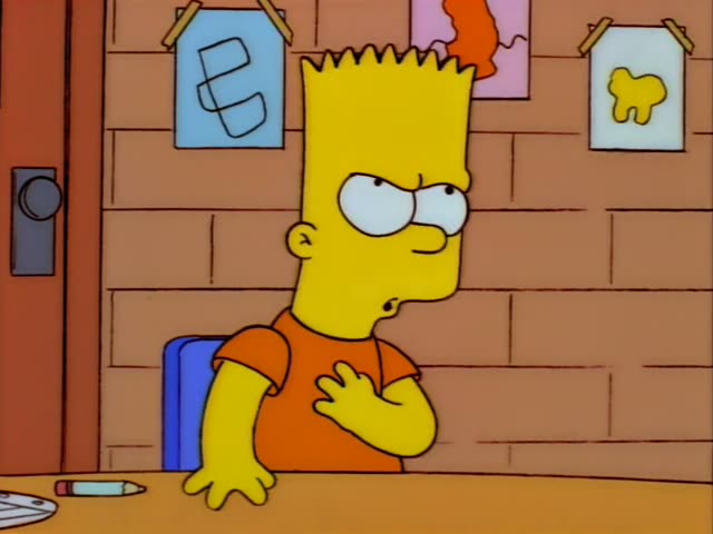 Bart Simpson sits at a classroom desk in his orange shirt while a tall woman with a light blonde ponytail, glasses and a red…