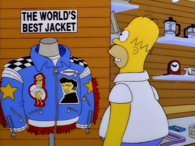 Homer stands at a shop counter beside a mannequin wearing a blue leather jacket with checkered shoulders, star patches…