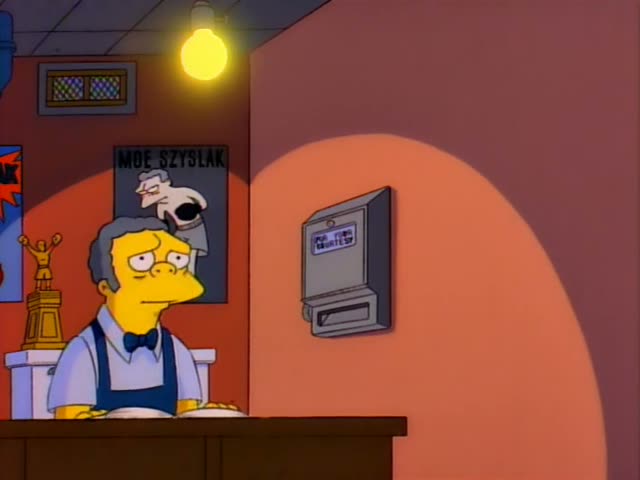 Moe stands behind the bar counter of his tavern beside a wall poster reading 'Moe Szyslak' and a coin telephone, with a blue…