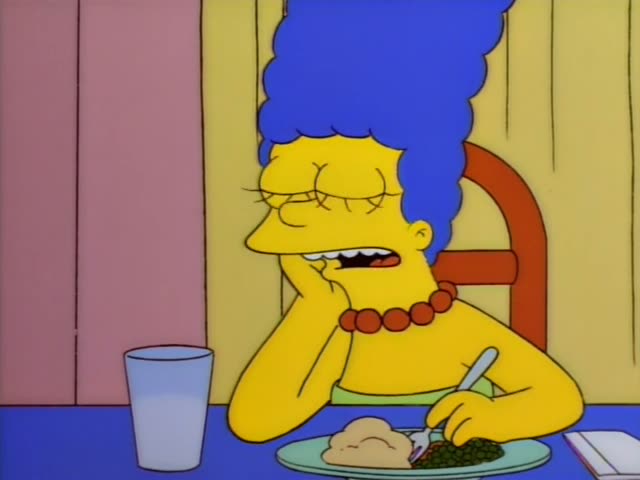 Marge sits at the dinner table with her chin in her hand, eyes half-closed and mouth open in a yawn, then grimaces…
