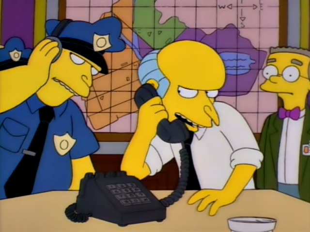 Chief Wiggum stands at left with a hand to his head while Mr. Burns presses a black telephone to his ear and Smithers…