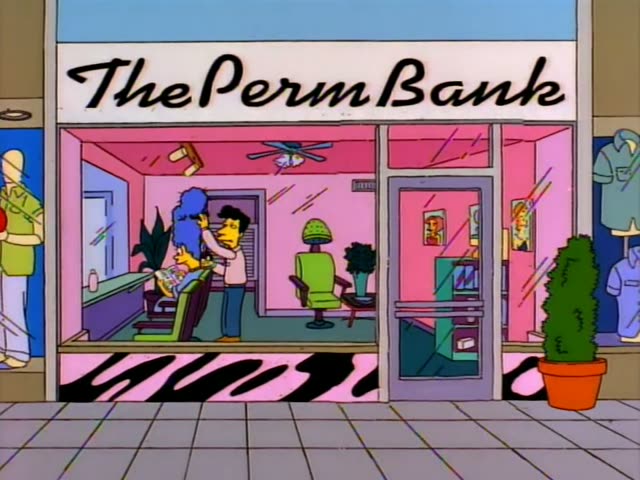 Marge Simpson sits in a green salon chair reading a magazine with a baby on its cover while a stylist with curly black hair…