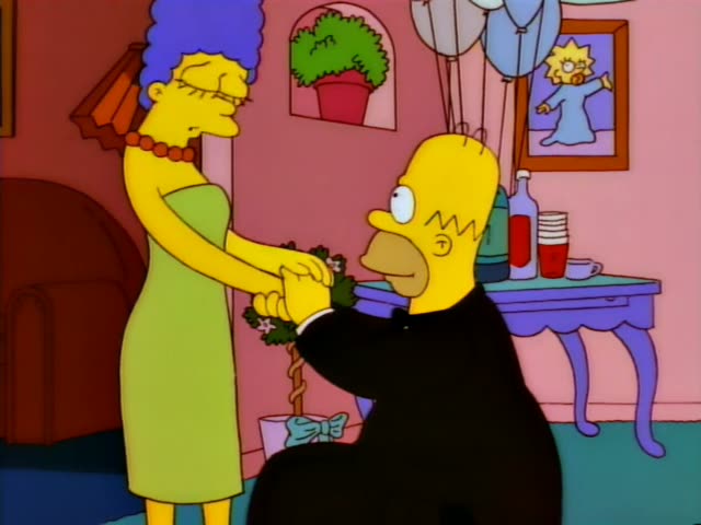 Marge Simpson stands in the pink living room with Homer, who wears a black tuxedo, as they hold a small potted topiary…