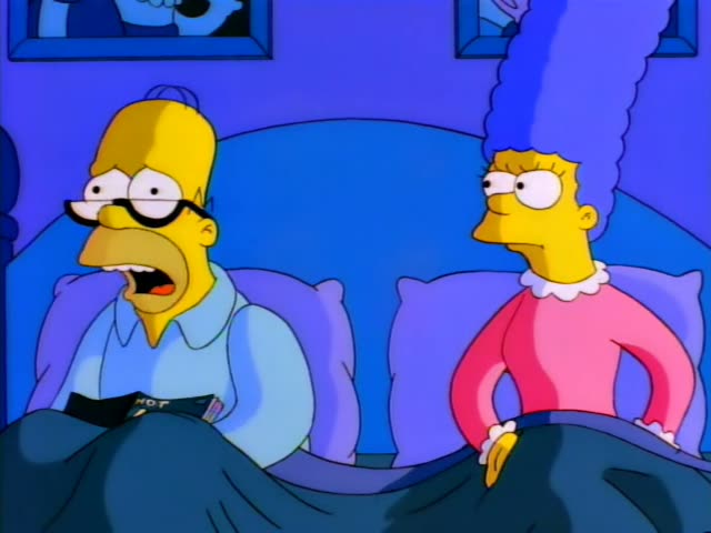 Homer Simpson and Marge Simpson lie side by side in bed under a dark blue blanket in a blue bedroom