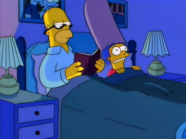 Homer sits up in bed reading a book while Marge peeks out from under the covers wearing a wide-eyed, nervous grin, and he…