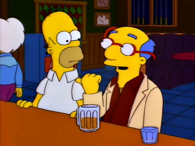 Homer Simpson sits at a bar beside a bald-topped man with a blue fringe, red-framed glasses and a tan jacket…