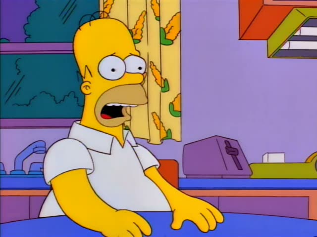 Homer Simpson sits at a kitchen table with a blue tablecloth, first gazing wide-eyed and speaking with his mouth open…