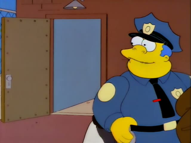 Chief Wiggum stands outside a brick building with a metal door while a second officer walks through the doorway behind him