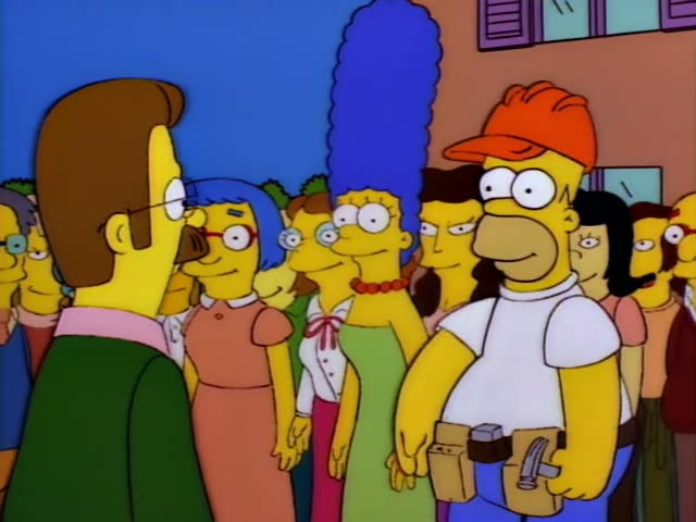 Homer stands in a crowd outside a building with purple shutters alongside Marge and Ned Flanders in a green sweater…