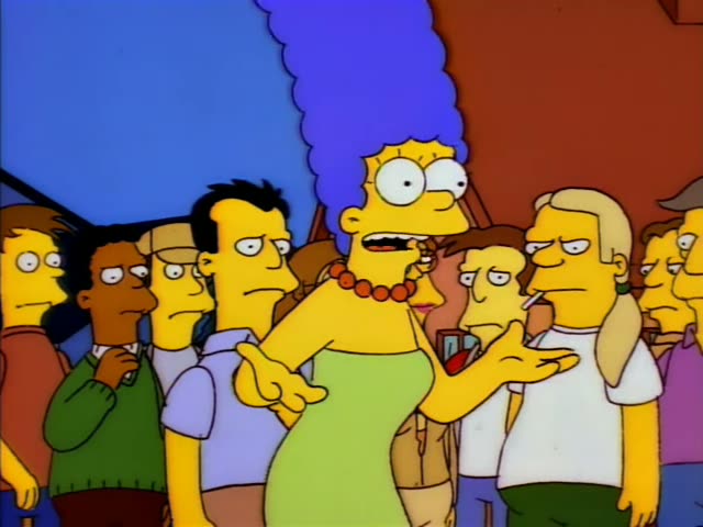 Marge Simpson stands in a crowd of townspeople outside a house with a red roof, grimacing and raising a hand to her throat…