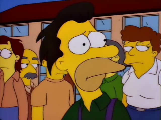 Homer stands at the front of a crowd outside a building with blue windows, while Ned Flanders in a green sweater and pink…