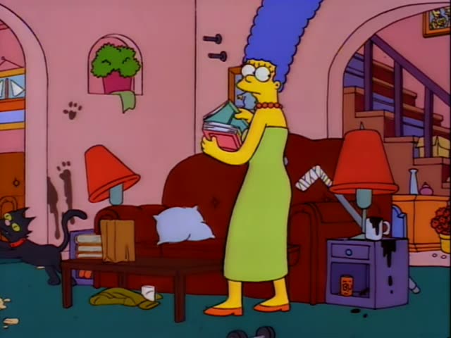Marge Simpson carries a stack of books through the cluttered pink living room while Snowball II stands near the sofa…