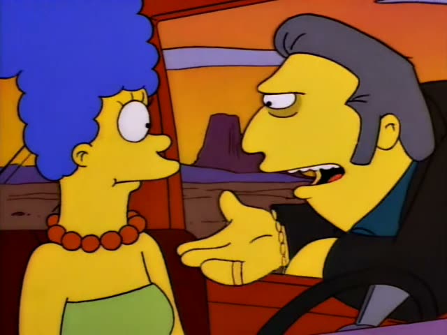 Marge sits beside a slick-haired man in a dark jacket and gold bracelet who is at the wheel of a car